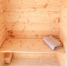 Klappbank in Sauna aus Holz mit Handtuch